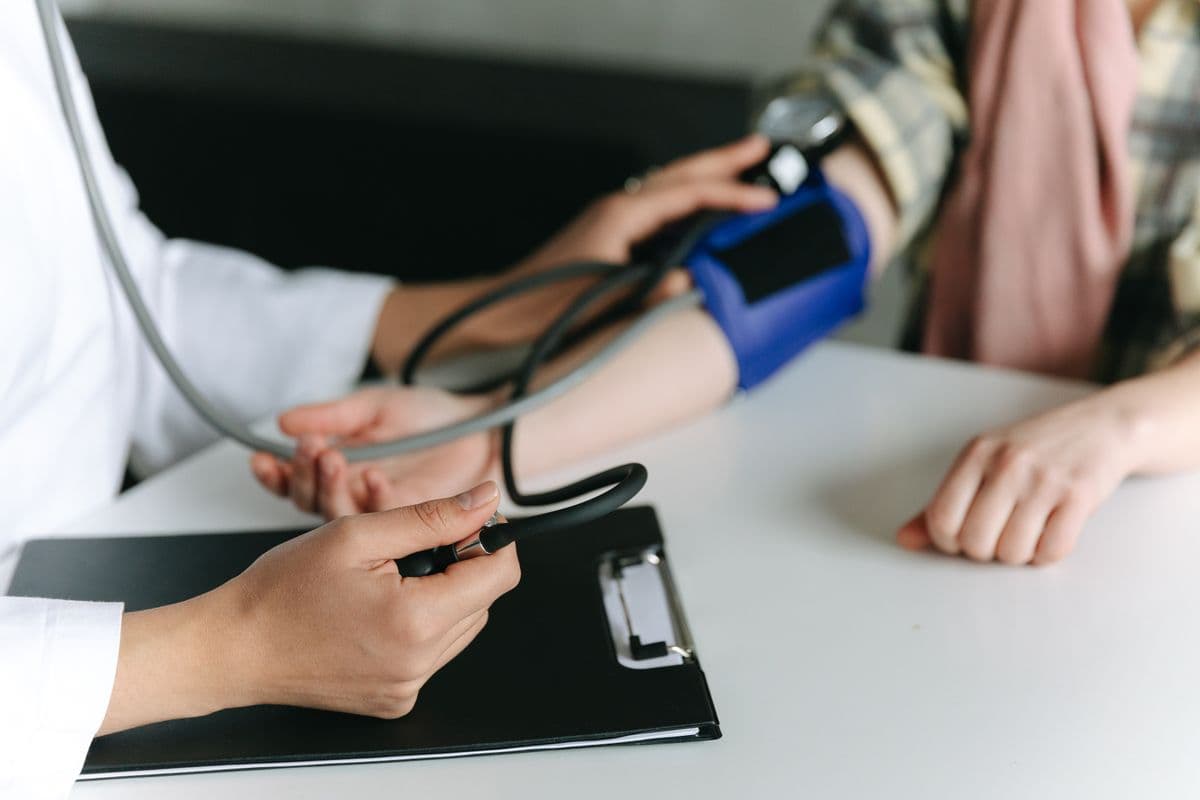 A community nurse checking a client's blood pressure during a home visit